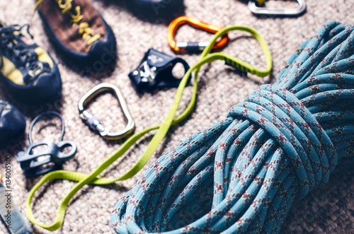 Climbing and mountaineering equipment on a carpet. Shoes, carbine, rope, lope, ascend-er. Concept of outdoor and extreme sport. 