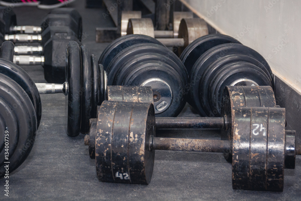 Several dumbbell lies on a floor.