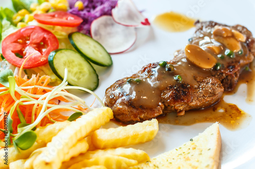 Beef steak with black pepper sauce and vegetables.