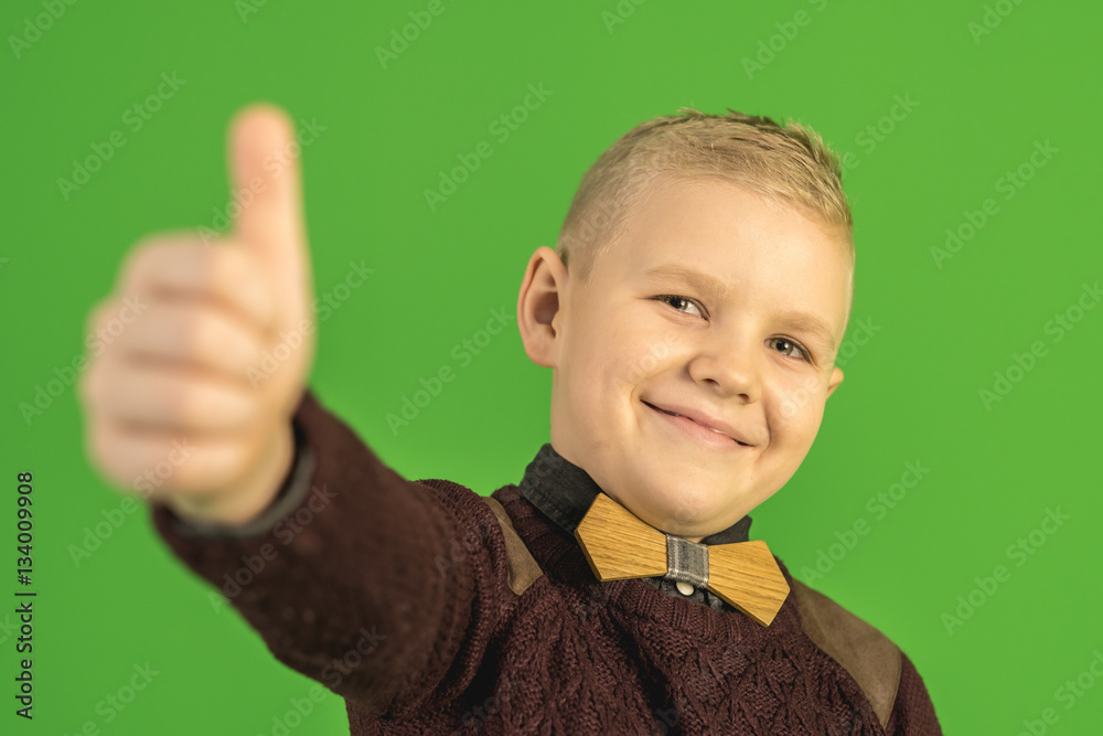 The beautiful boy show thumb up on the green background The beautiful boy show thumb up on the green background