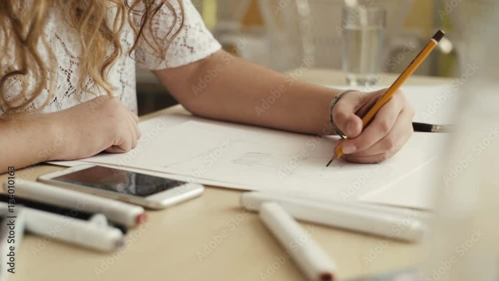 Designer draw sketches in the Studio. Attractive woman working. Workspace designer. White sheet of paper, pencil, markers, felt-tip pens.