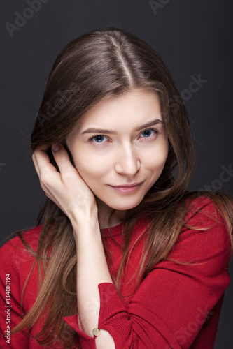 Portrait of a woman on a gray background in red sweater
