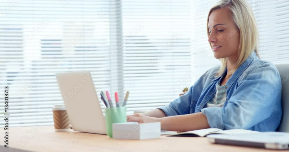 Businesswoman working over laptop at her desk Businesswoman working over laptop at her desk