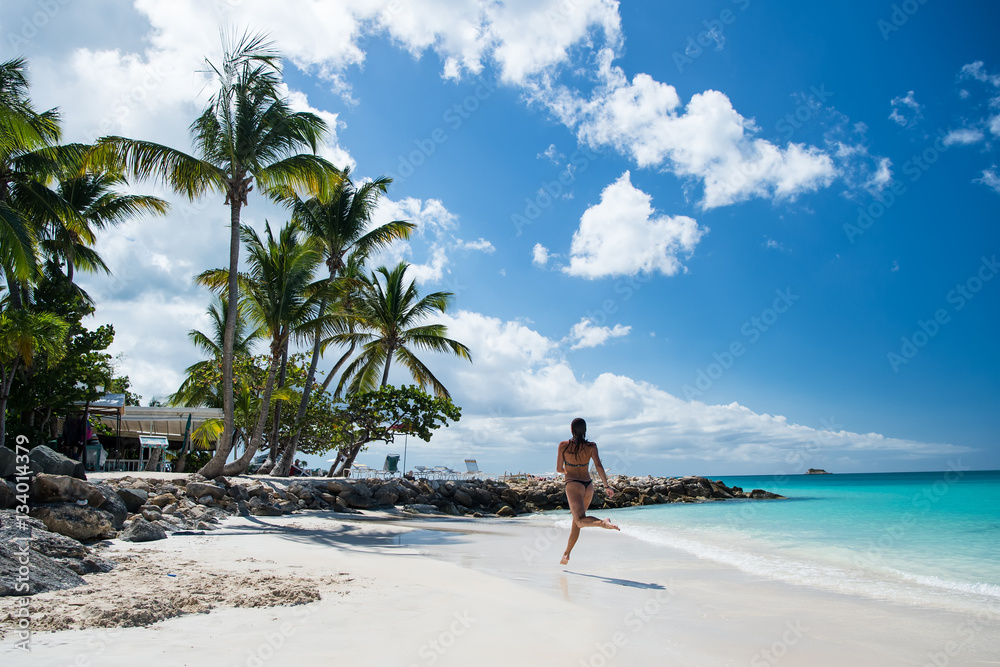 Obraz premium Young woman running at the tropical beach