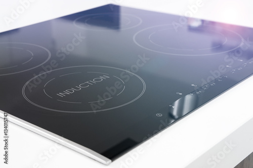 Modern black induction cooker on white countertop photo