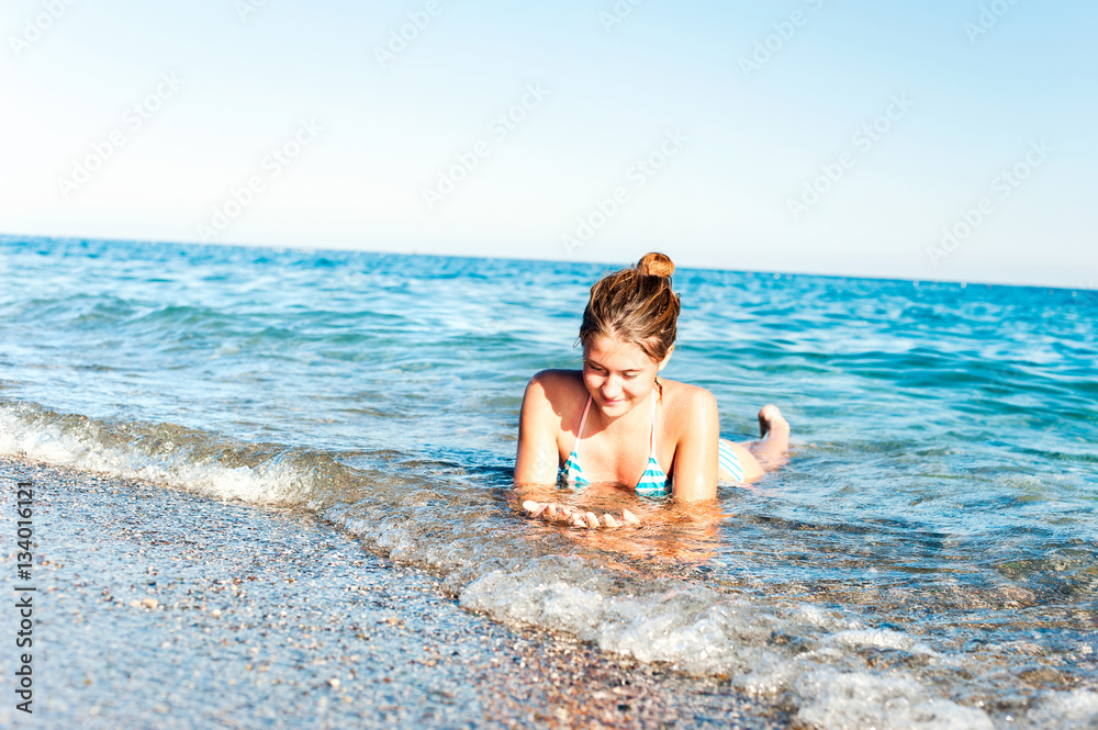 Happy young girl enjoying in sea splashing waves. Mediterranean Happy young girl enjoying in sea splashing waves. Mediterranean