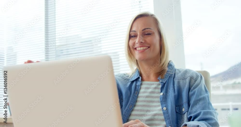 Businesswoman closing laptop at her desk Businesswoman closing laptop at her desk