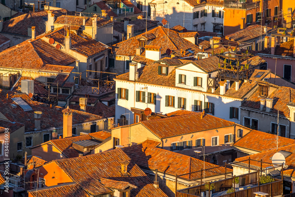 Aerial view of Venice, Italy, at sunset with rooftops of building, the sea and warm sunlight. Aerial view of Venice, Italy, at sunset with rooftops of building, the sea and warm sunlight.