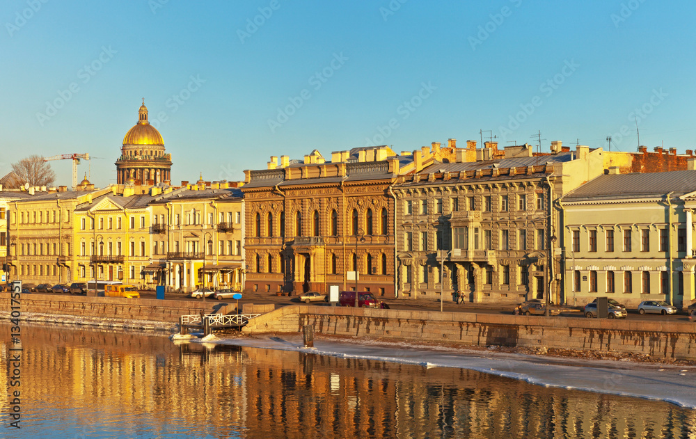 Saint Petersburg. English Embankment (Angliyskaya Naberezhnaya) of the Neva River and the dome of St. Isaac's Cathedral in the sunset light spring