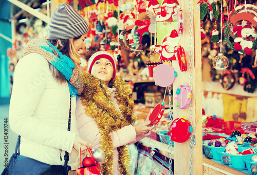 Glad woman with small daughter in market