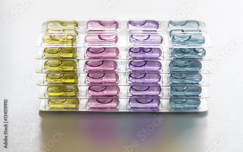 Colorful Capsule pills in packages use in pharmaceutical manufacturing, drug, medicine, garlic oil, fish liver oil. photo