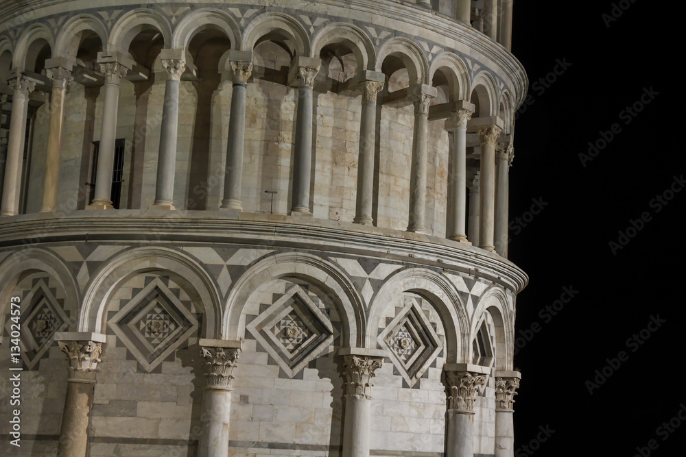 Pisa tower at night - fragment of the Pisa leaning tower on dark sky background.