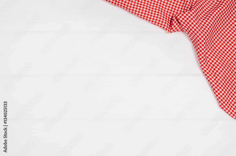 Top view of red checkered napkin or tablecloth on white wooden table with visible planks, texture and copy space for text. Top view of red checkered napkin or tablecloth on white wooden table with visible planks, texture and copy space for text.