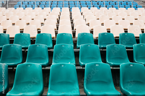 Part of a tribune of old stadium with the seats painted in different colors