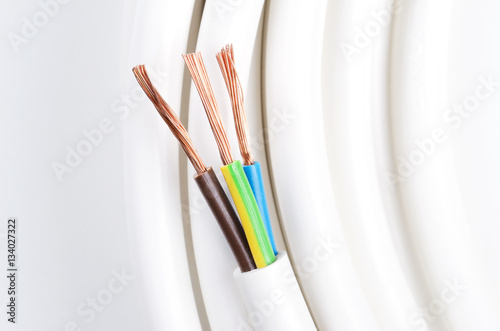Electrical cable with three insulated conductors. Power cable cross-section. Cable jacket with wire insulation and flexible stranded copper wires. IEC standard color code. Macro photo from avove. photo