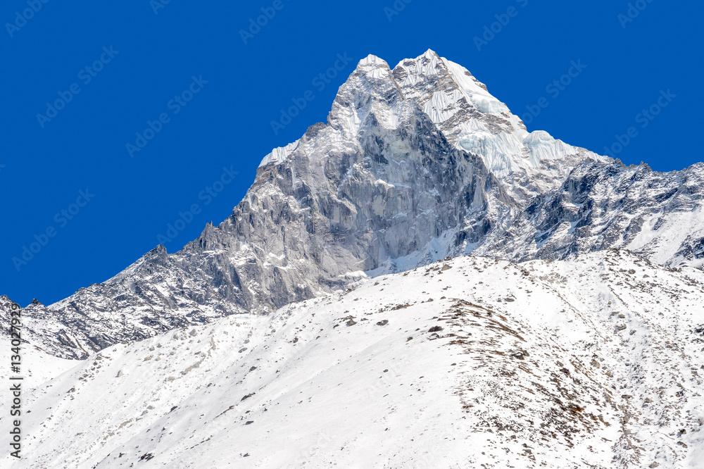 Snowy peak over blue sky (Ama Dablam in the Everest Region)