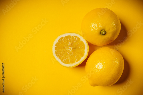 some delicious and fresh lemons on a yellow background