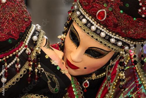 Amazing kiss during Venice Carnival, two performers with beautiful costume and venetian mask kissing each other, symbol of love and creativity, amazing romantic couple