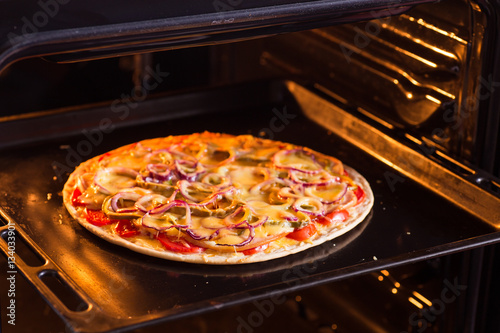 Pizza is cooked in the oven (close)