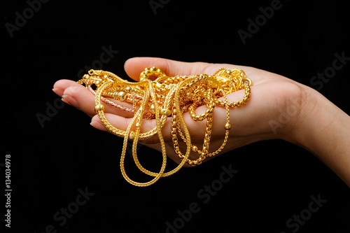 Hand Holding Expensive Gold Jewelry necklace and bracelet