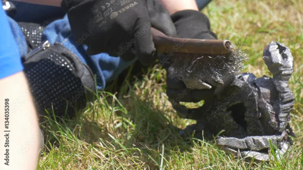 Man Cleans a Metal Statuette From a Slag Man Cleans a Metal Statuette From a Slag