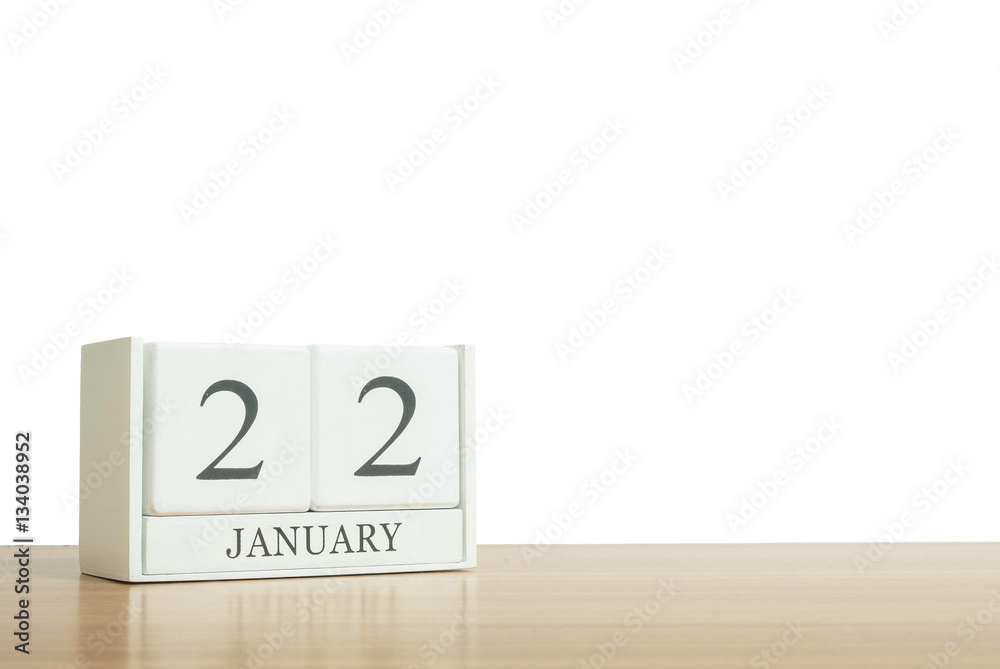 Closeup surface white wooden calendar with black 22 january word on blurred brown wood desk isolated on white background with copy space , selective focus at the calendar Closeup surface white wooden calendar with black 22 january word on blurred brown wood desk isolated on white background with copy space , selective focus at the calendar