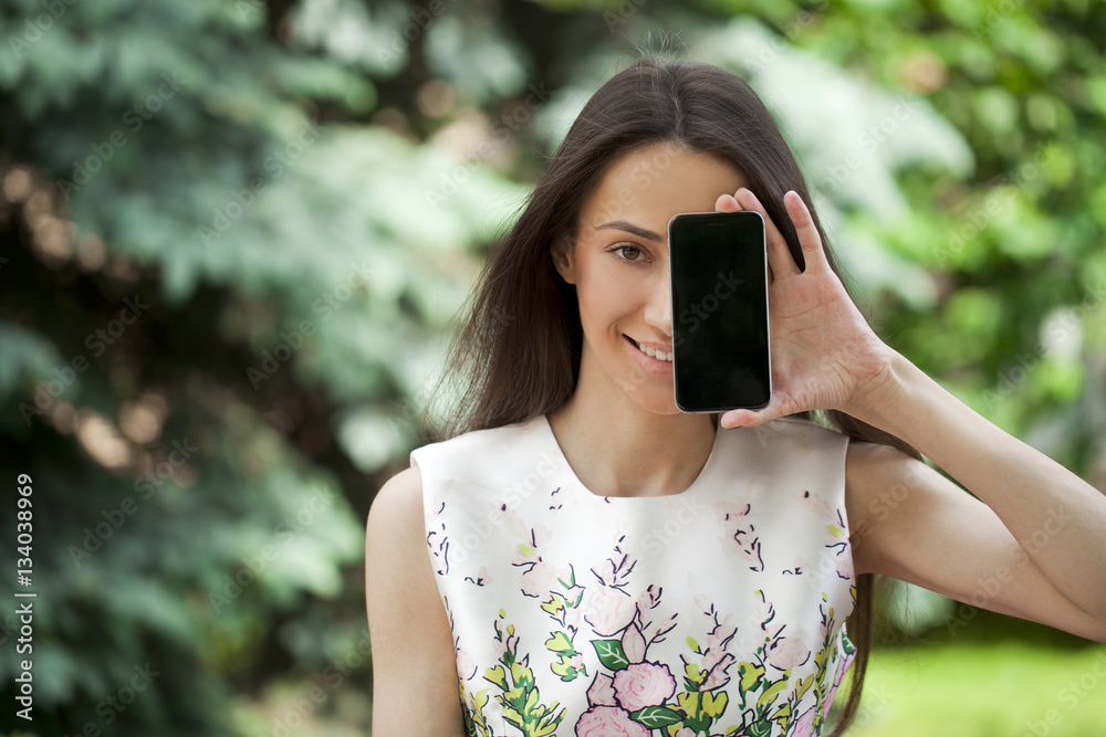 Young beautiful girl showing your smartphone screen