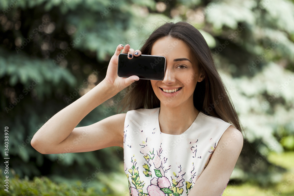 Young beautiful girl showing your smartphone screen