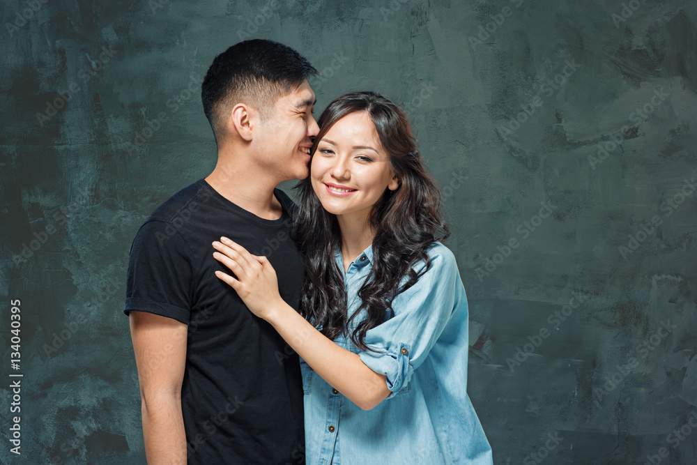 Portrait of smiling Korean couple on a gray Portrait of smiling Korean couple on a gray