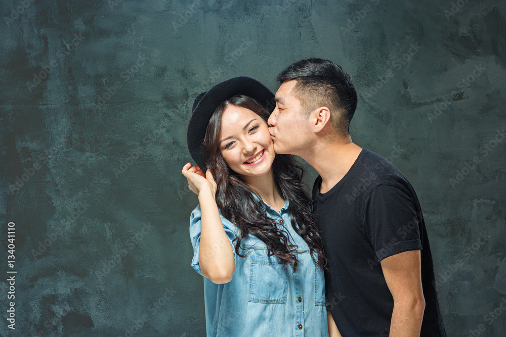 Portrait of smiling Korean couple on a gray - obrazy, fototapety, plakaty 