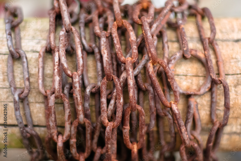 Rusty chain wound on a wooden post. Rusty chain wound on a wooden post.