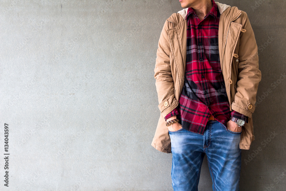 Men's casual outfits wear blue jeans with red plaid shirt, brown coat and  leather bag standing over gray grunge background with space, lifestyle  traveler, beauty and fashion concept Stock Photo