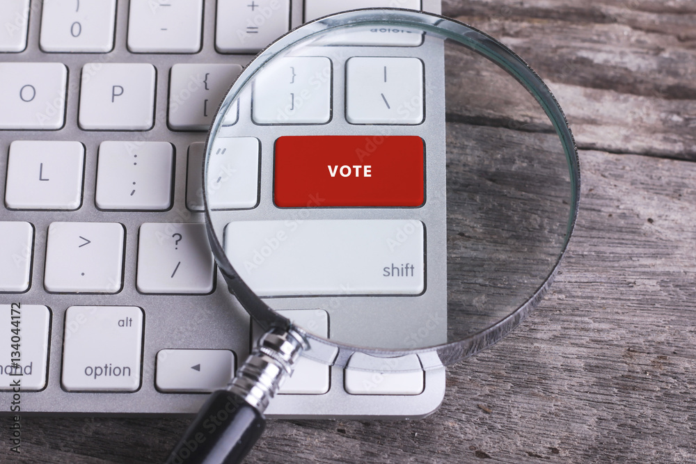 Business concept: VOTE on computer keyboard on wooden background Business concept: VOTE on computer keyboard on wooden background