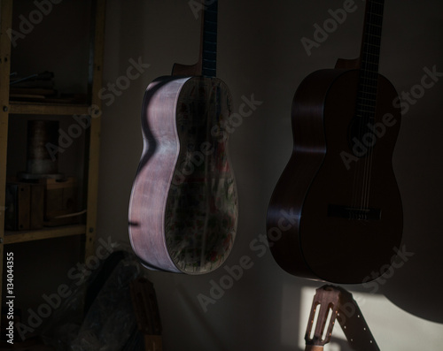 a row of classical unfinished guitar at workshop in sunlight © asayenka