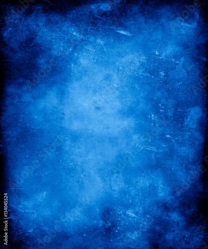 Blue grunge vintage textured background with faded central area for your text or picture.