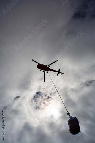 Helicopter working on transporting material. Dangerous work.