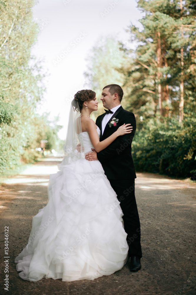 Elegant young happy wedding couple is sitting at green grass on Elegant young happy wedding couple is sitting at green grass on
