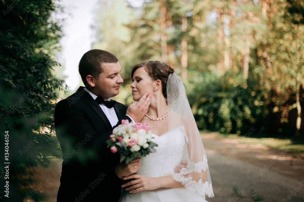 Elegant young happy wedding couple is sitting at green grass on Elegant young happy wedding couple is sitting at green grass on