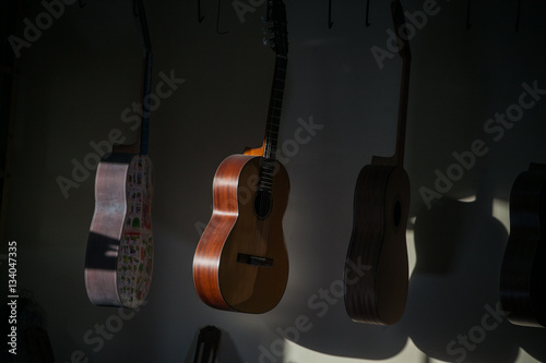 a row of classical unfinished guitar at workshop in sunlight © asayenka