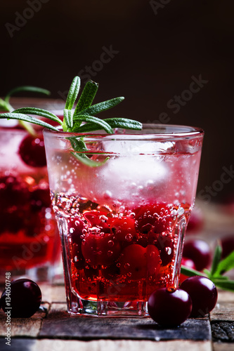 Two-layer cocktail with cranberry vodka, rosemary, soda and ice,