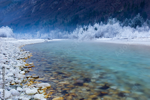 Turquoise River Soca with frozen trees in winter
