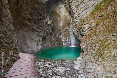 Wood bridge to frozen Waterfall and green colour river Pool photo