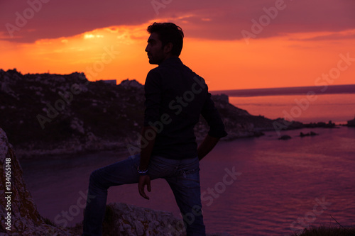 man standing thinking back light sunset lighting side view profile silhouette summer evening beach