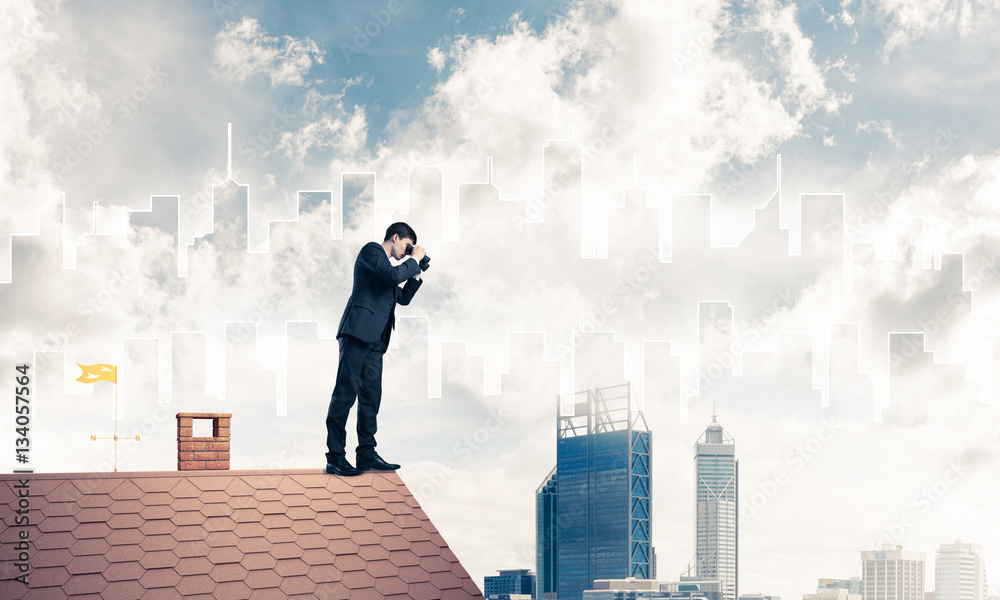 Businessman standing on roof and looking in binoculars. Mixed me Businessman standing on roof and looking in binoculars. Mixed me