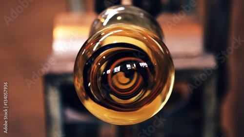 Close-up of molten glass on a blowpipe at glassblowing factory photo