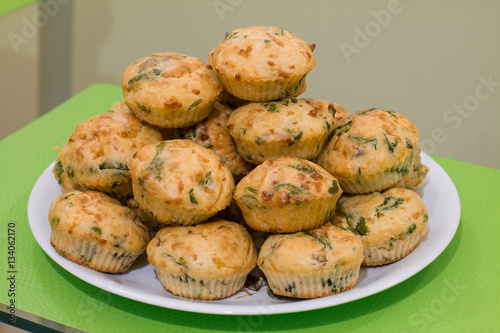 Muffins with salmon, spinach and cheese in a big plate on glass table