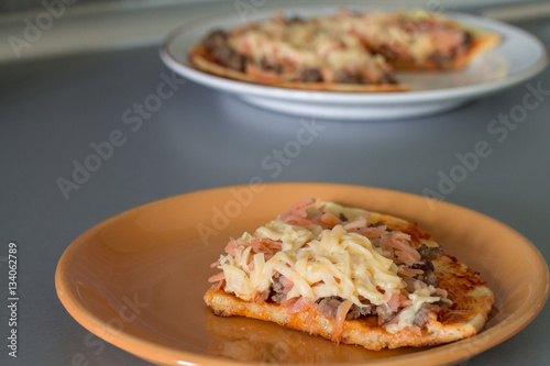 Frittata with tomato sauce  carrot  fried minced beef and cheese on white plate.