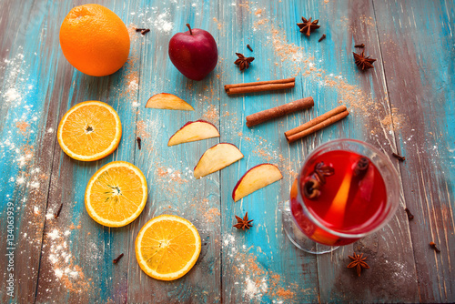 Orange, apple, cinnamon, anise, wine (mulled wine) on wooden background
