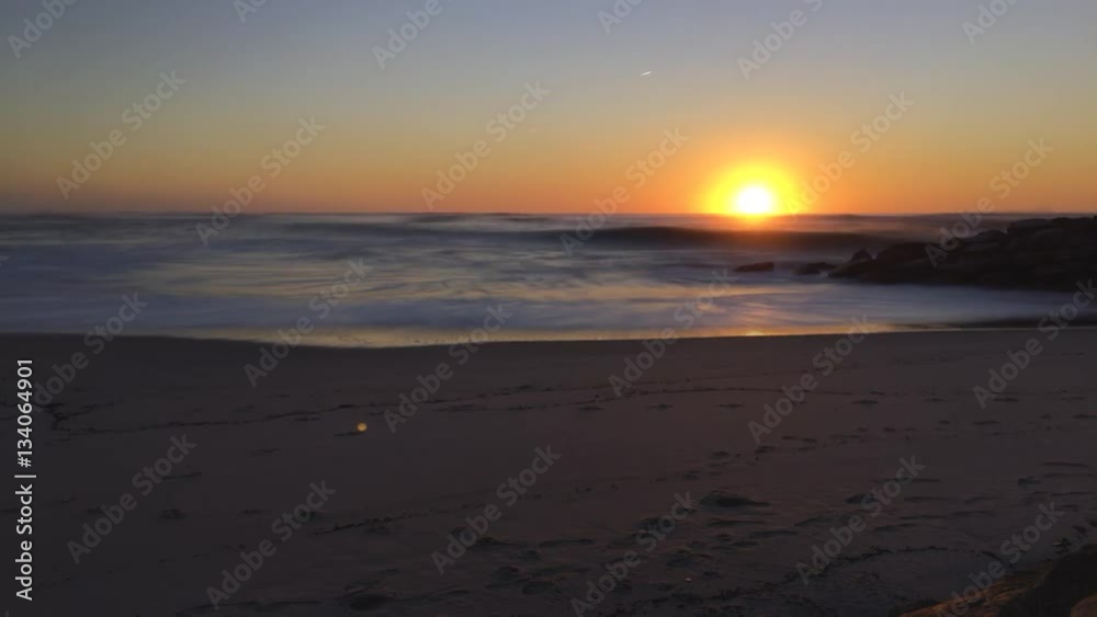 Sunset timelapse with waves crash on shore on a sandy beach. Sunset timelapse with waves crash on shore on a sandy beach.