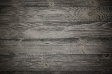 Old weathered wood surface with long boards lined up. Wooden planks on a wall or floor with grain and texture. Dark neutral tones with contrast.